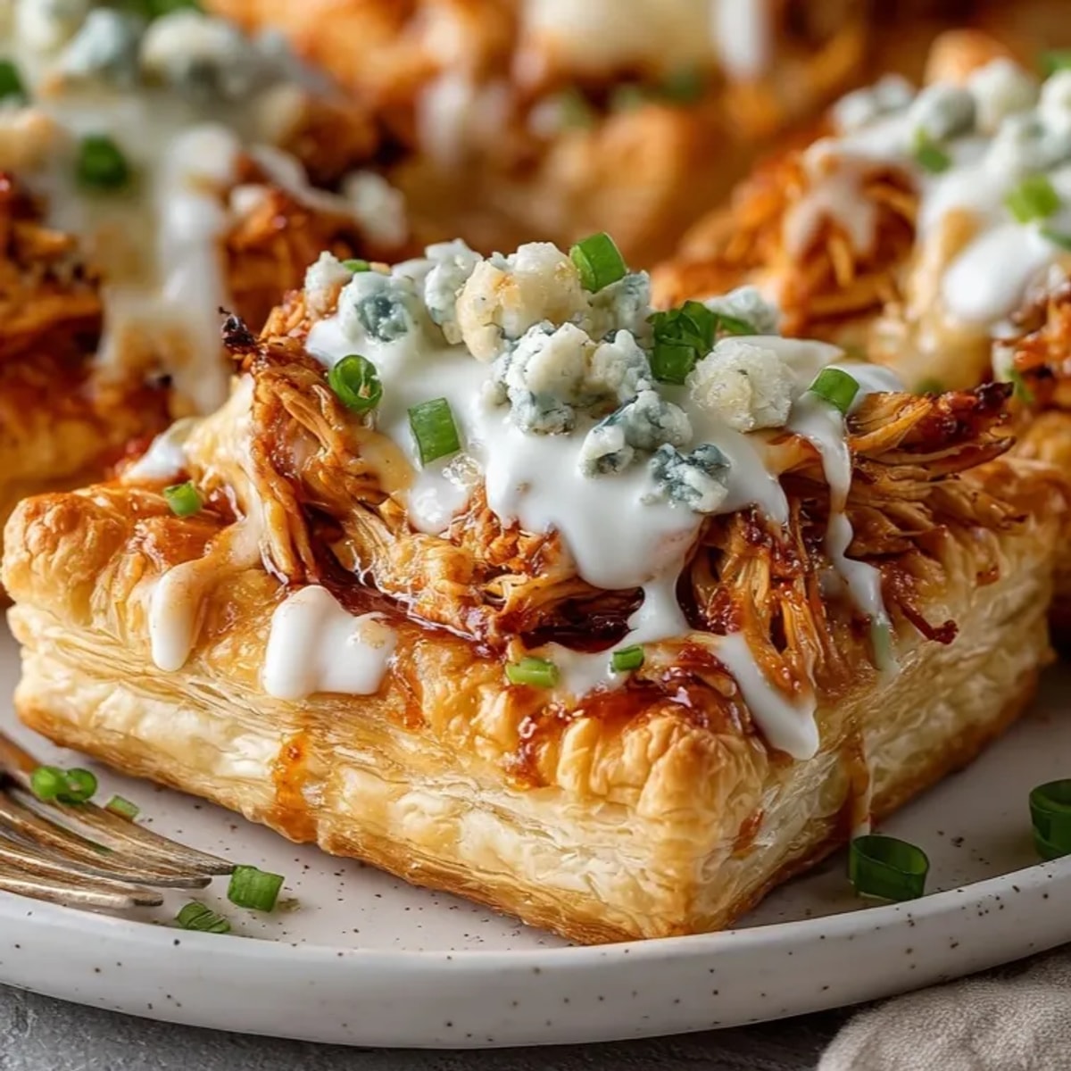 Crispy Buffalo Blitz Puff Pastry Bites, golden brown and topped with tangy buffalo sauce.