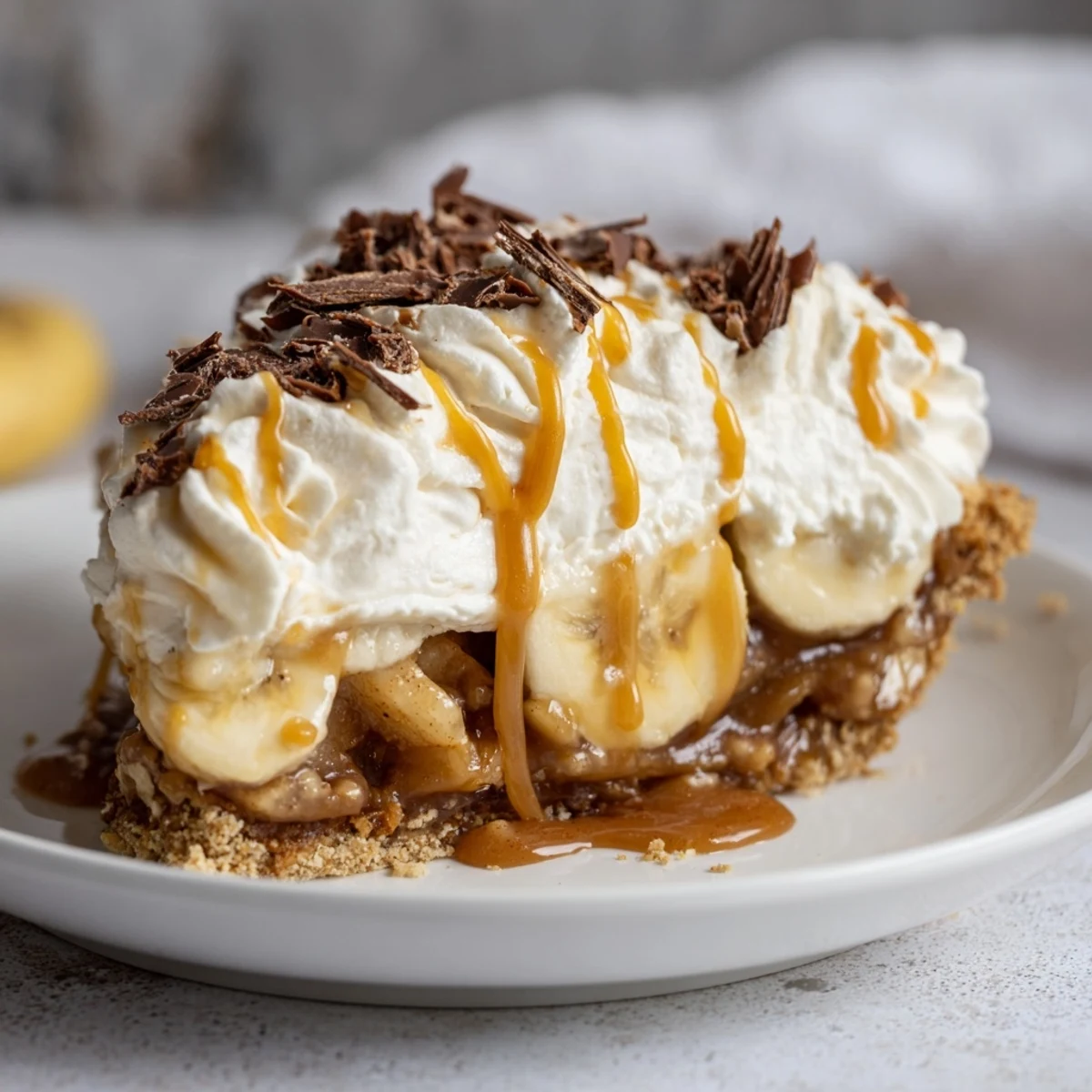 Luscious caramel apple banoffee pie topped with whipped cream and dark chocolate shavings.  