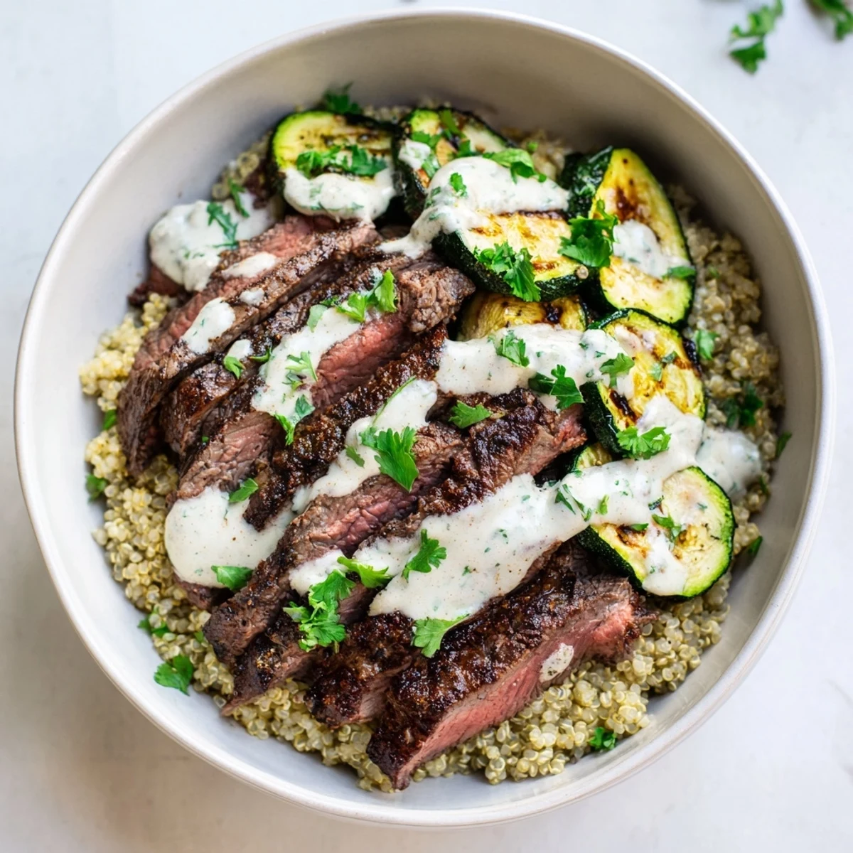 Grilled Steak Bowl with Creamy Sauce & Grilled Zucchini topped with fresh herbs and vibrant flavors.