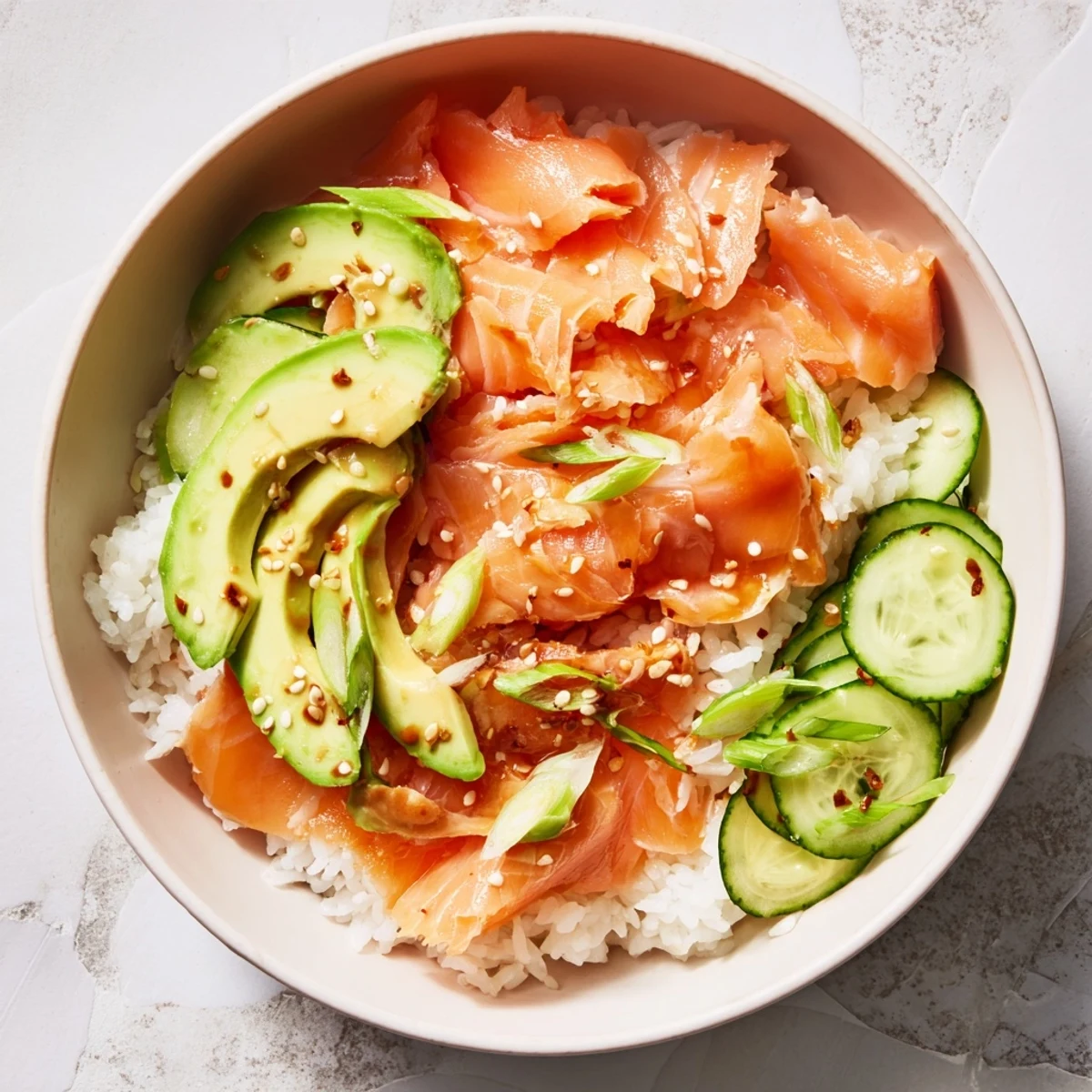 Colorful salmon and rice bowl, steaming hot, drizzled with soy sauce and sesame oil.