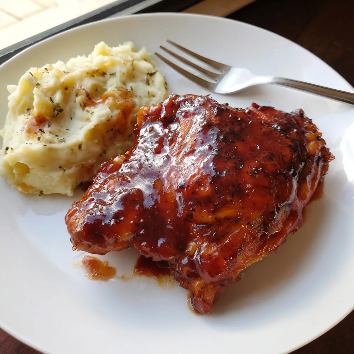 Succulent honey BBQ chicken thighs glazed with a sticky sauce, served with garlic mashed potatoes.  
