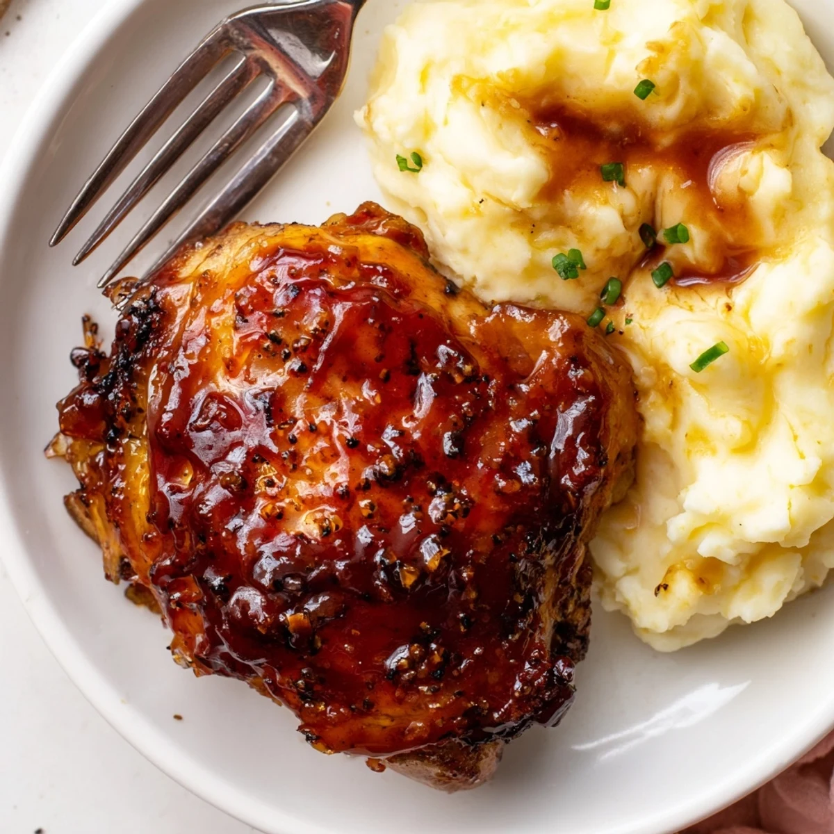 Golden, oven-baked honey BBQ chicken thighs paired with creamy, buttery garlic mashed potatoes.  