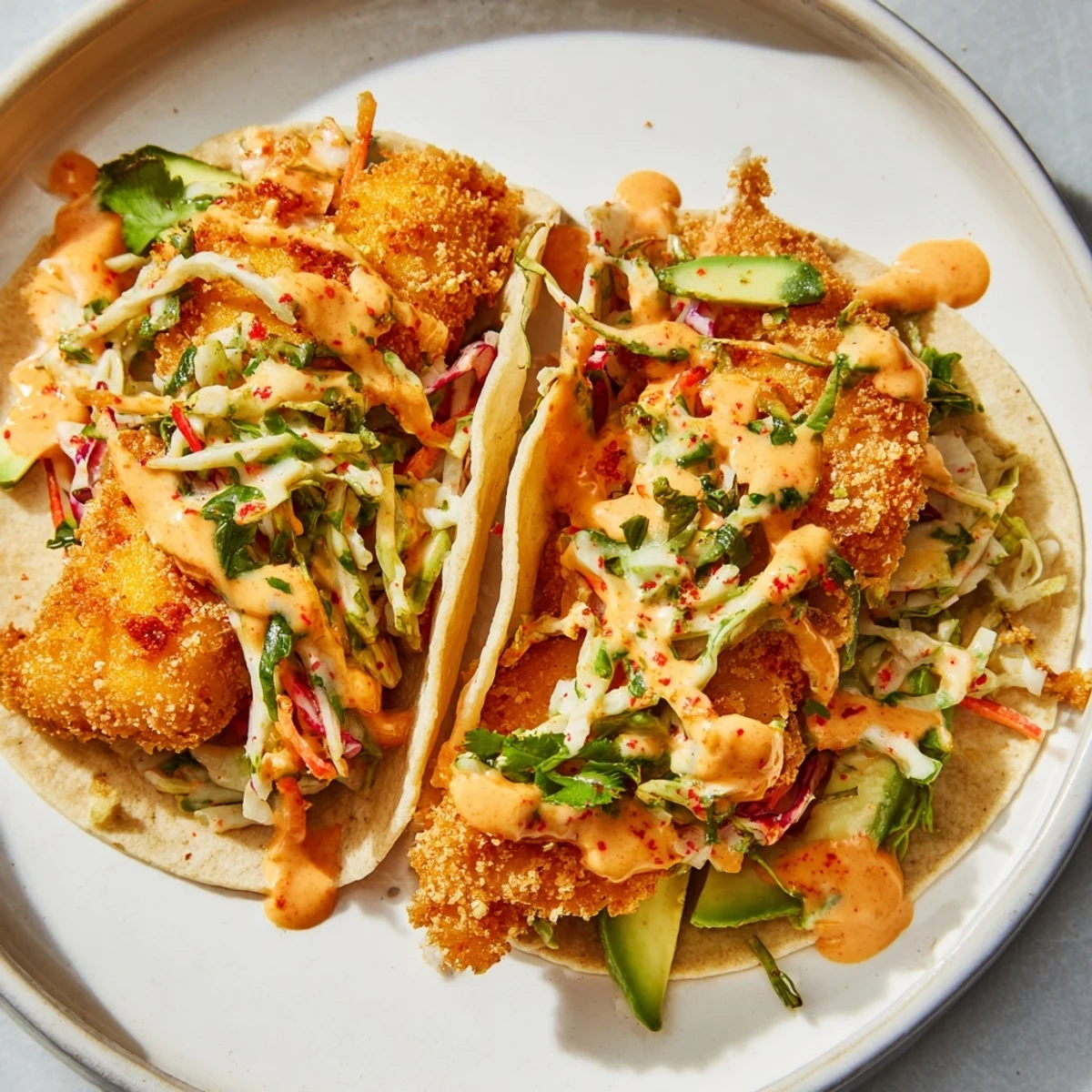 Golden, crispy fish tacos overflowing with fresh slaw, ready to be enjoyed with lime wedges.