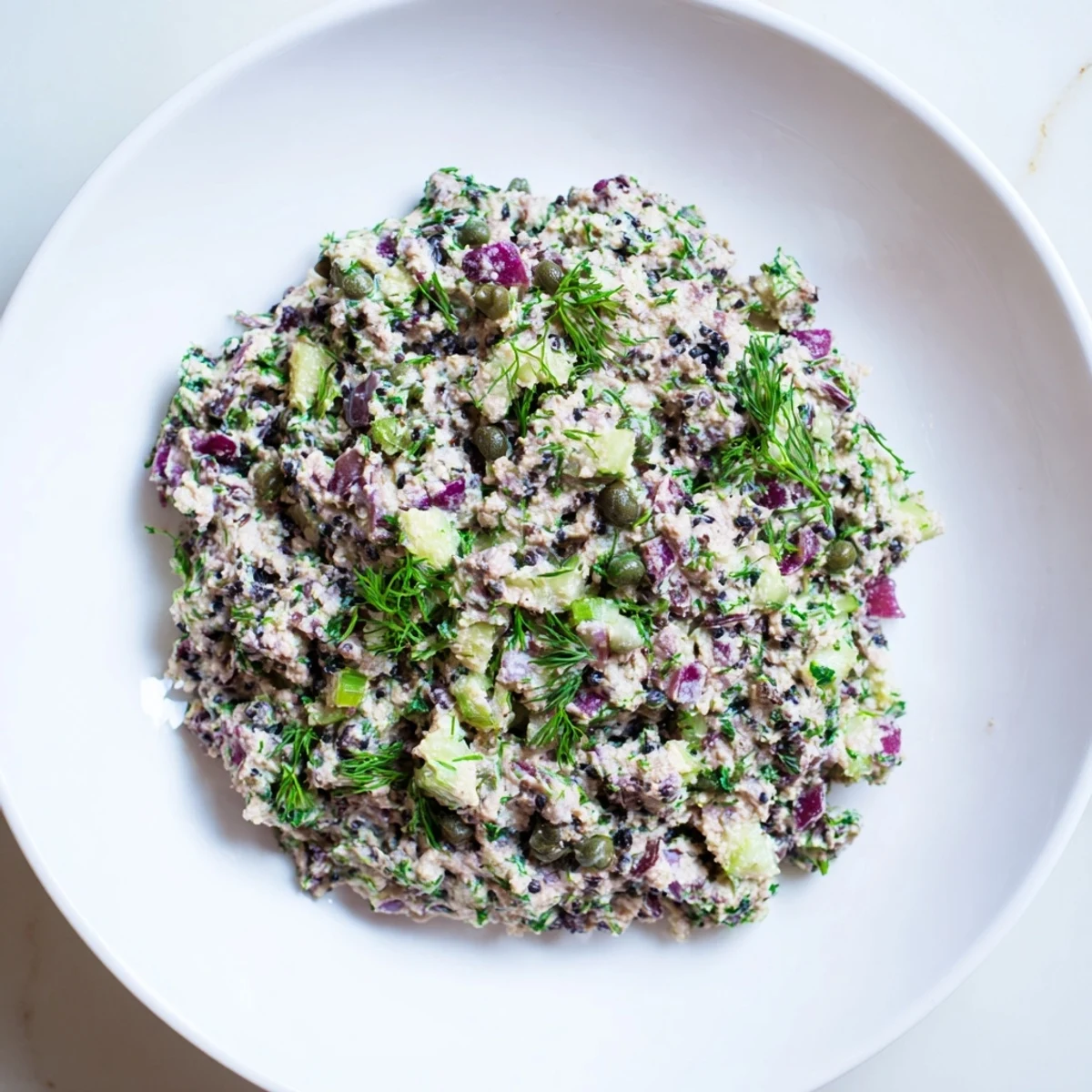 Vibrant chickpea tuna salad with visible diced vegetables and a creamy, plant-based dressing.