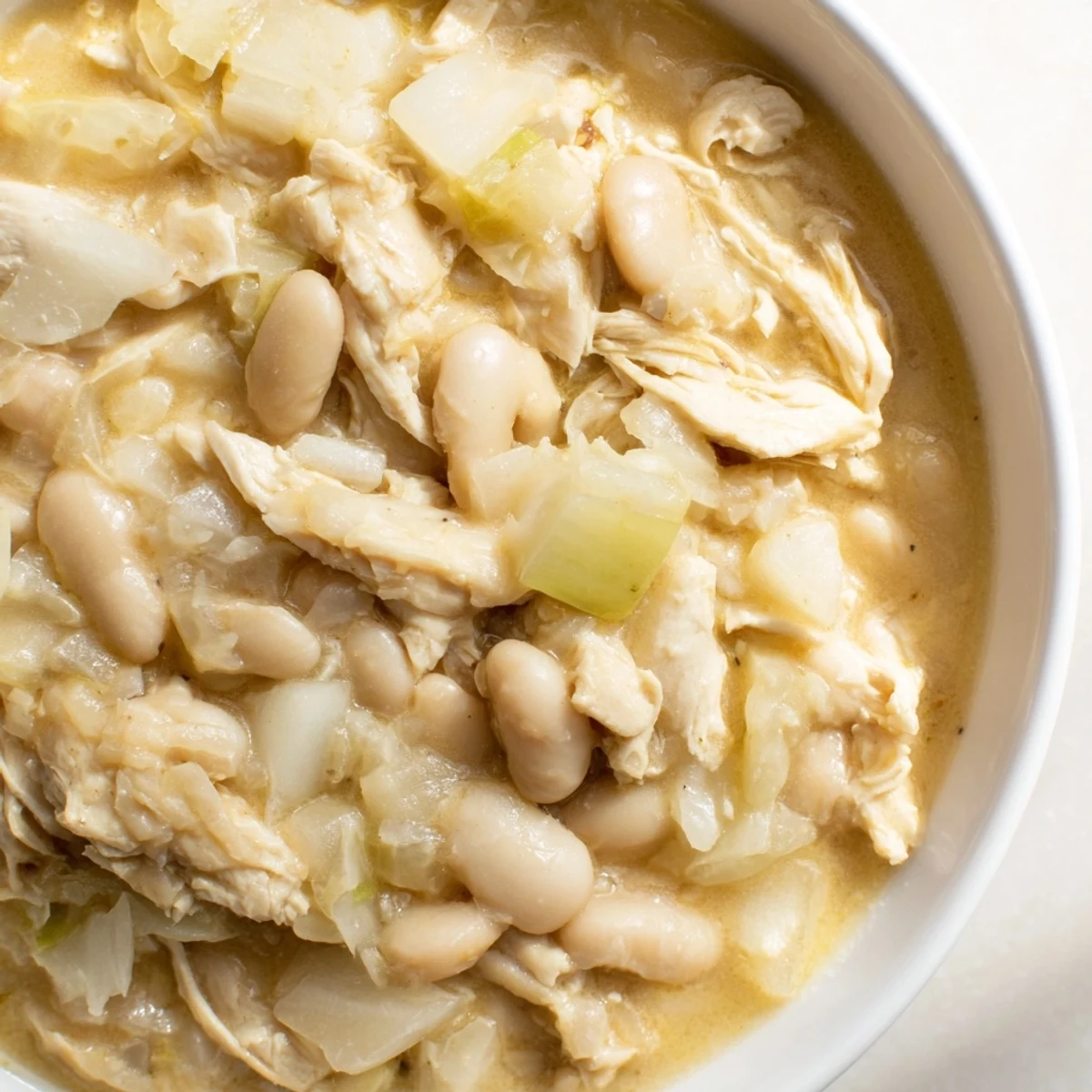Creamy 35-Minute White Cheddar Apple Chicken Chili, showcasing tender chicken and sweet apple chunks in a rich broth.