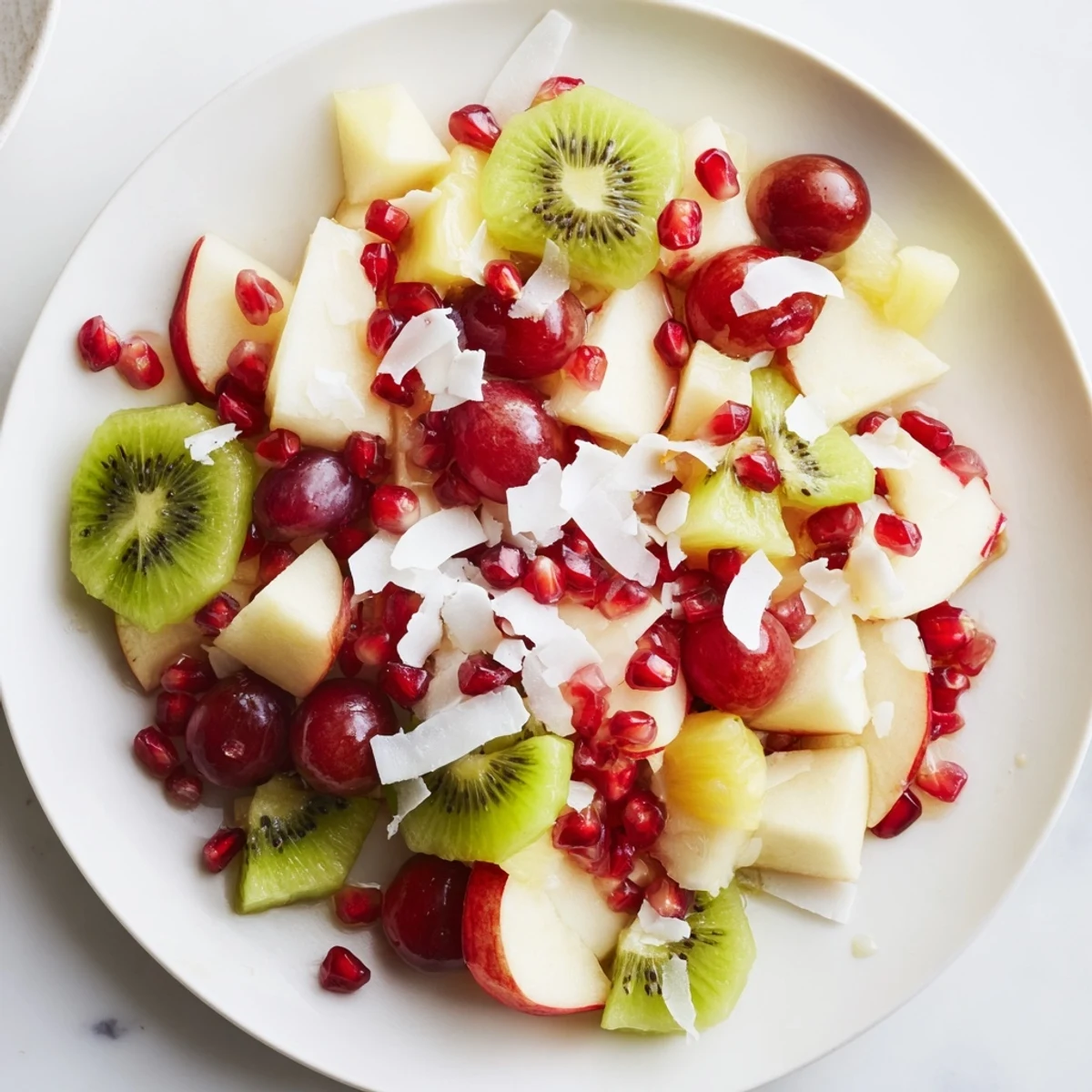 Snowflake Fruit Medley glistens with vibrant pomegranate and kiwi, inviting refreshment, artfully arranged.