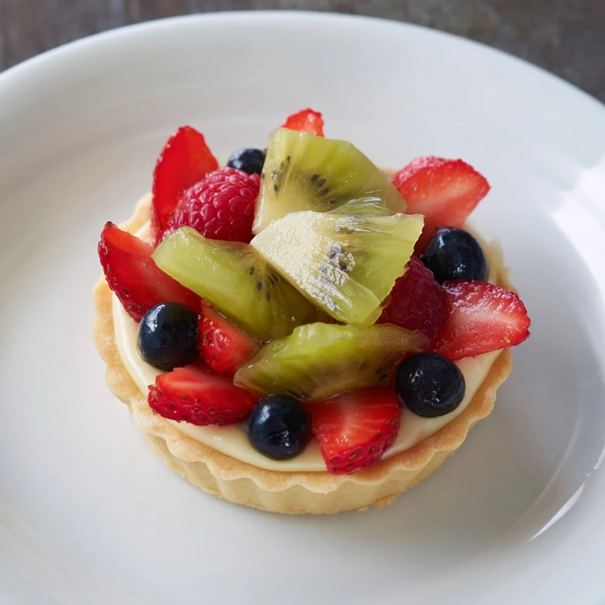 Circular arrangement of sweet Mini Fruit Tartlets, showcasing vibrant colors of fresh berries and kiwi.