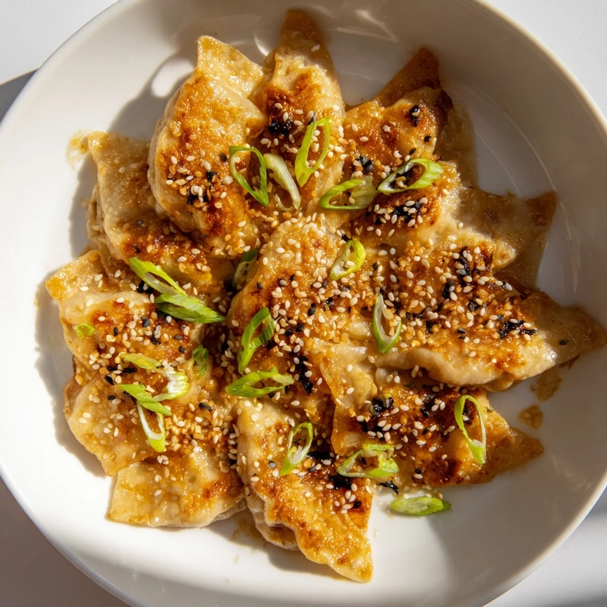 Golden brown air fryer frozen dumplings, glistening with sesame oil, ready to be served hot.