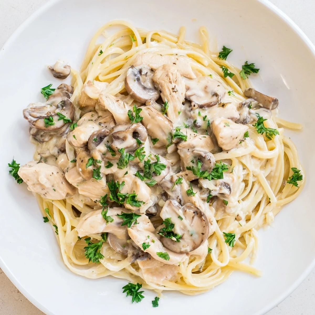 A close-up of Creamy Mushroom Chicken Spaghettini reveals twirled pasta strands, sliced chicken, and herbs, highlighting the dish's comforting, restaurant-quality appeal.