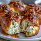 Golden-brown Hot Honey Ricotta Stuffed Garlic Knots fresh from the oven on a serving plate.