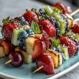 Colorful fruit kabobs arranged in rainbow order, paired with a luscious honey-lemon yogurt dip, perfect for healthy snacking or party platters.