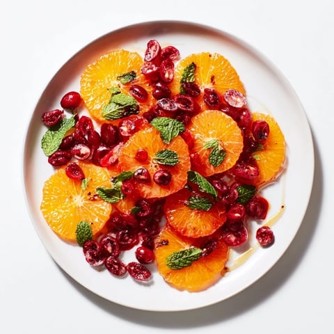 Vibrant winter fruit salad with orange slices and cranberries, a refreshing side dish for your holiday table.