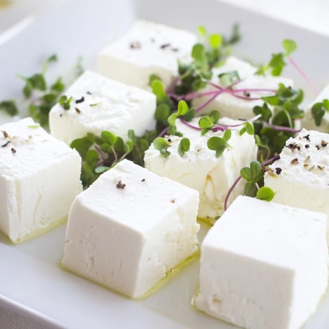 A colorful checkerboard garden appetizer featuring creamy cheeses and fresh, flavorful herb squares.