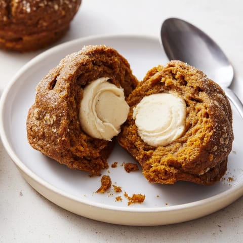Delicious gingerbread pumpkin muffins featuring a warm, spiced thumbprint center.  