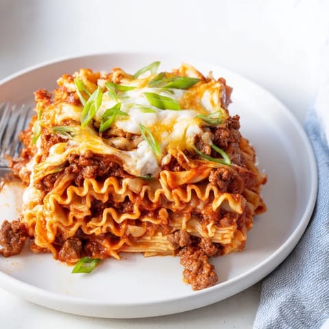 Comforting spicy ramen lasagna, showcasing bright colors and savory flavors in every layer.  