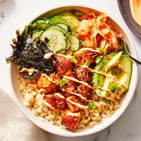 Delicious crispy salmon served in a bowl with garlic rice and tangy toppings.  