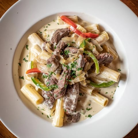 A skillet filled with the delicious Philly Cheese Steak Pasta, savory aromas filling the kitchen.