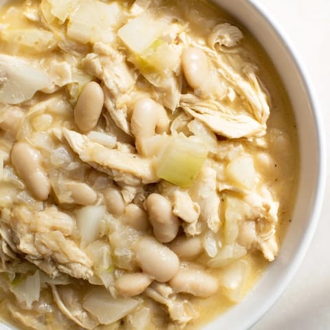 Creamy 35-Minute White Cheddar Apple Chicken Chili, showcasing tender chicken and sweet apple chunks in a rich broth.