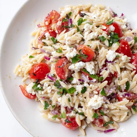 Bright, colorful close-up of Tomato Feta Orzo, a perfect Mediterranean side dish.