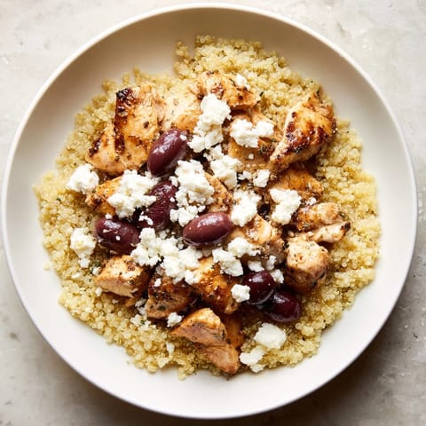 A Mediterranean Chicken Bowl topped with cucumber, chickpeas, and fresh parsley, drizzled with a lemon-oregano dressing.