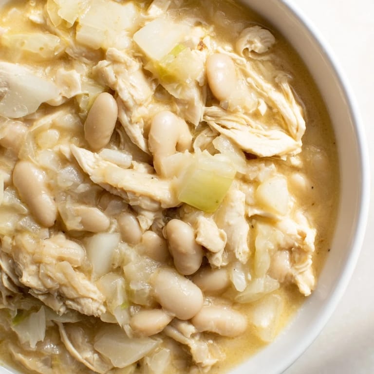 Creamy 35-Minute White Cheddar Apple Chicken Chili, showcasing tender chicken and sweet apple chunks in a rich broth.