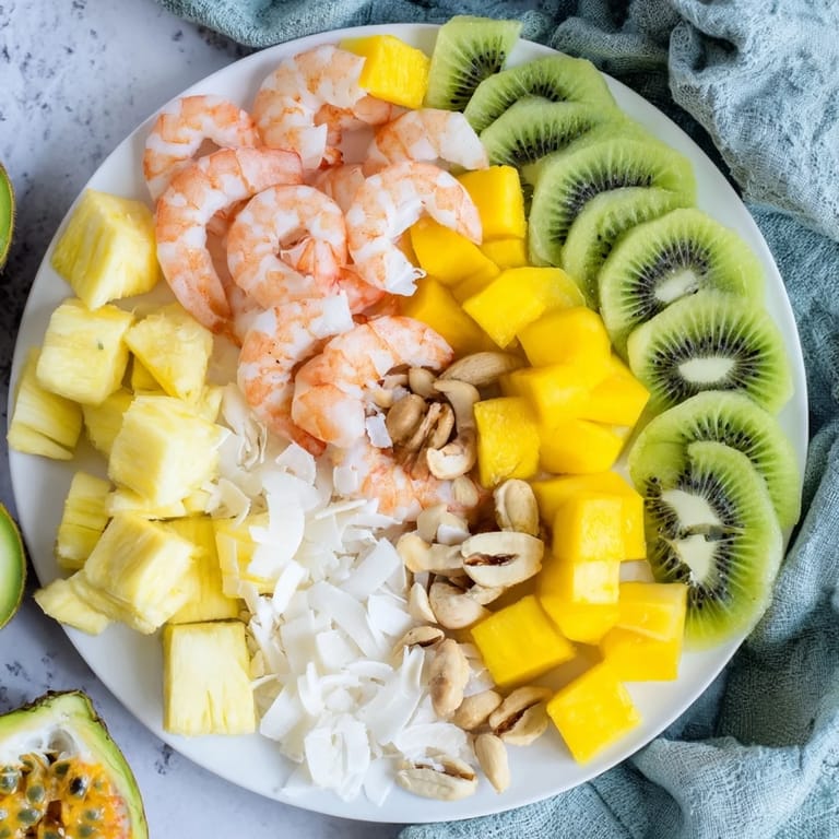 This shared Tropical Wave Tasting Platter features shrimp, salmon, and colorful tropical fruits ready to enjoy.