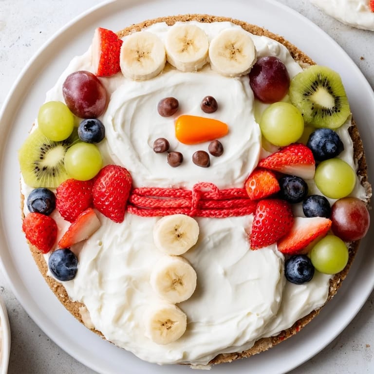 Bright and colorful Melting Snowman Fruit Pizza, featuring a sugar cookie crust and vibrant, fresh fruit toppings.