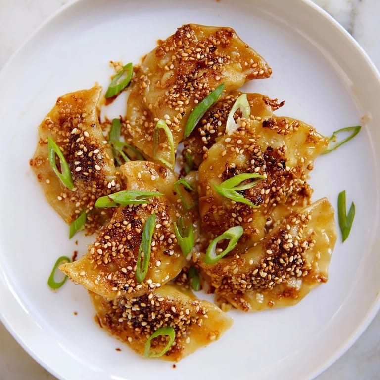 A close-up of air fryer frozen dumplings with a savory sesame oil glaze, perfect appetizer.