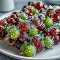Vibrant frozen grape skewers coated in zesty lime sugar, a refreshing and colorful summer snack perfect for entertaining.